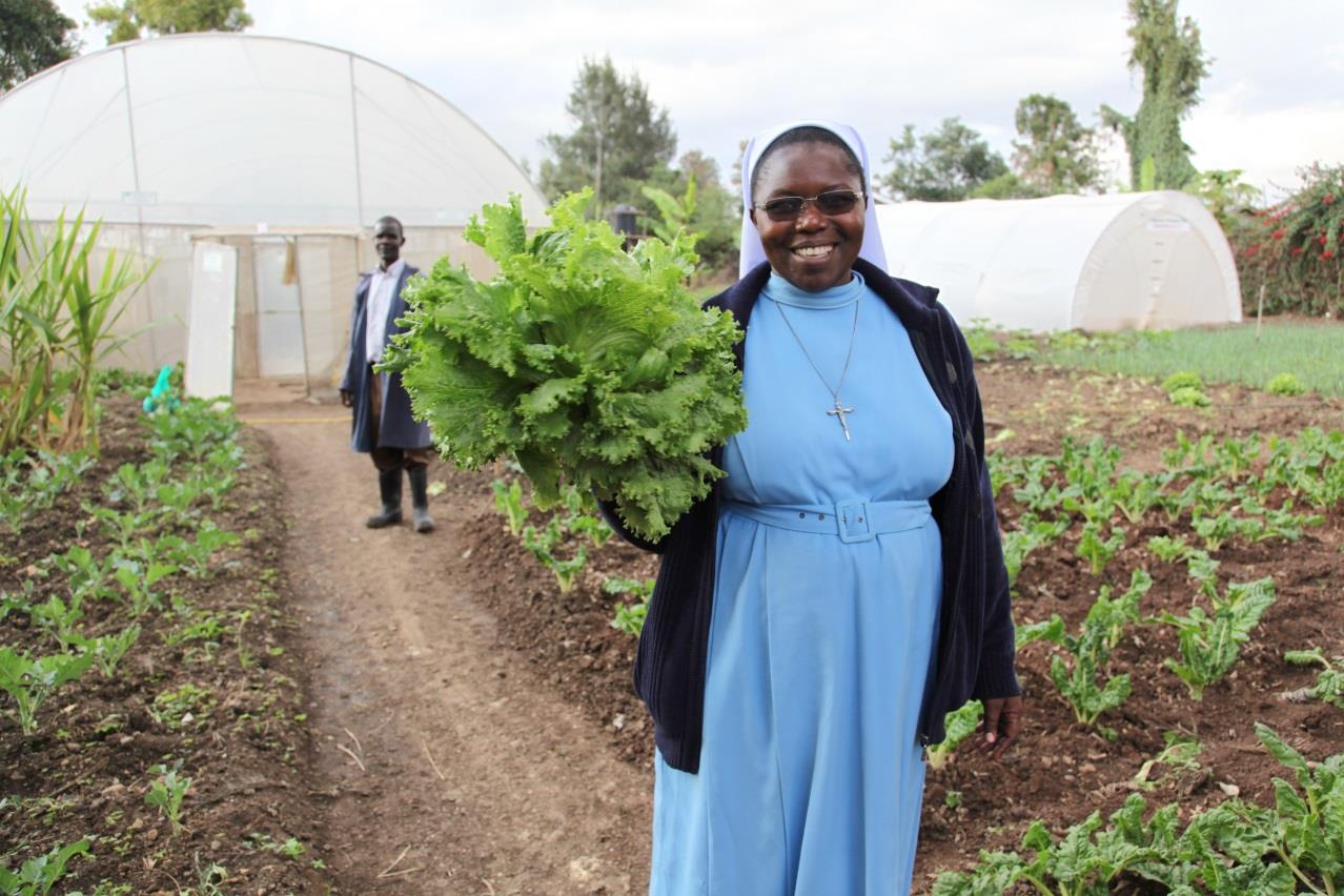 r. Catherine Owormungu shows off lettuce from the greenhouse farming project &ndash; increased food production to feed children in their schools.